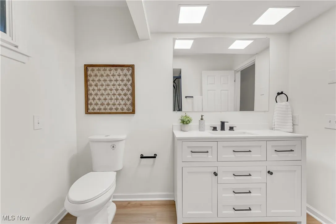 Bathroom featuring vanity, light wood-style flooring, and a shower with curtain