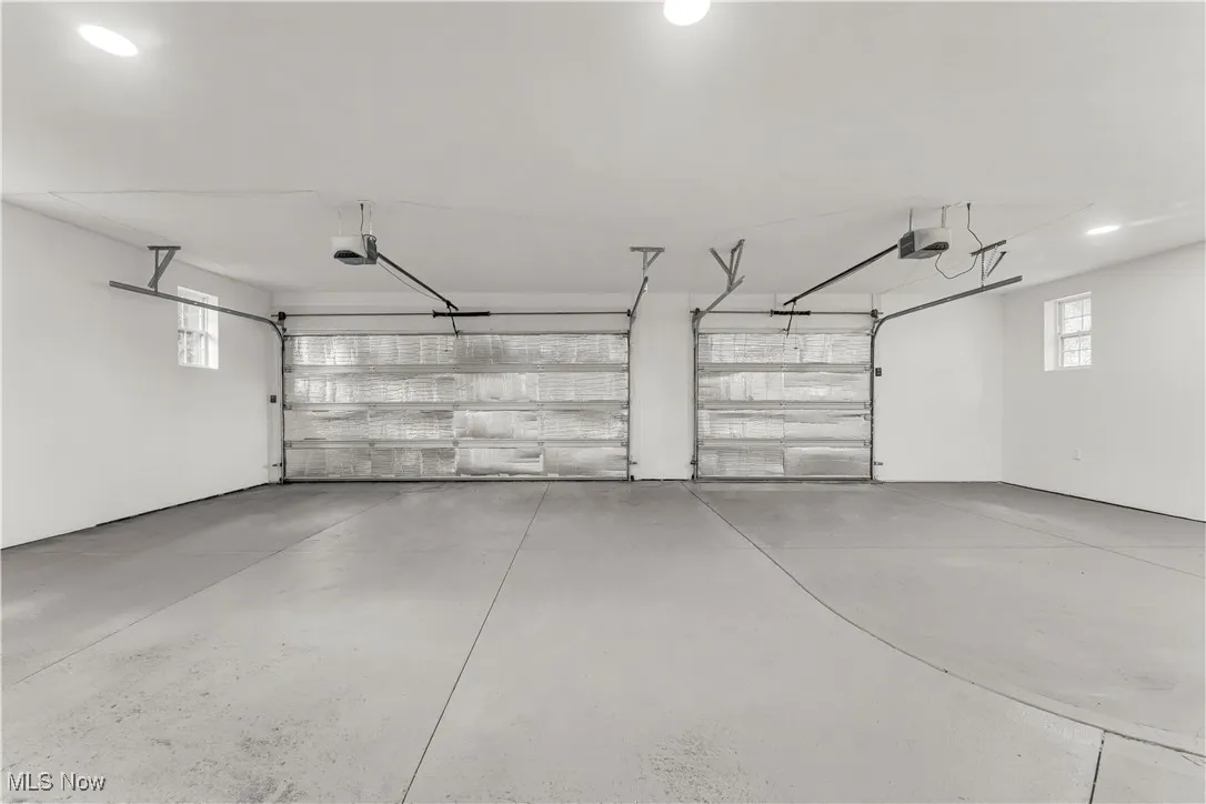 Garage featuring a garage door opener and recessed lighting