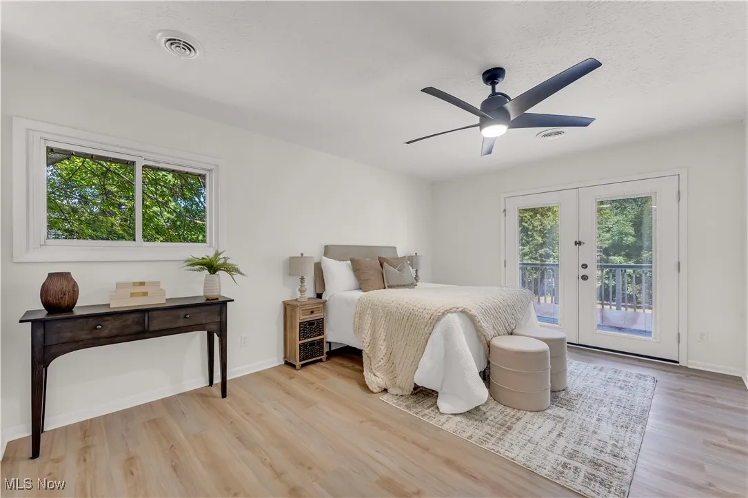Bedroom featuring access to outside, a ceiling fan, light wood-type flooring, french doors, and a textured ceiling