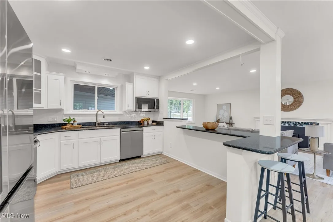 Kitchen featuring white cabinets, light wood finished floors, and recessed lighting