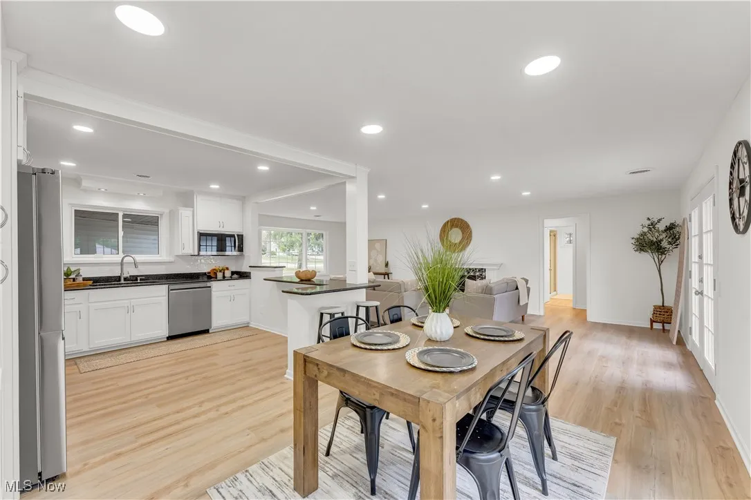 Dining area with light wood-type flooring and recessed lighting