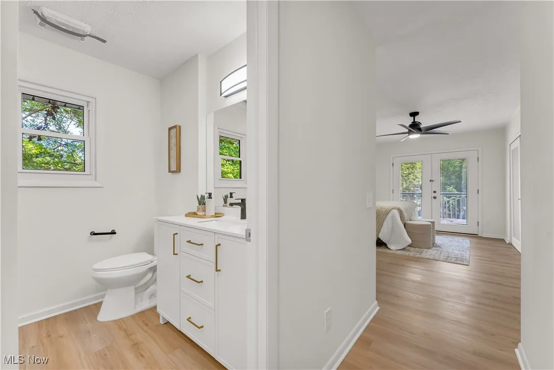 Half bathroom with vanity, light wood-style flooring, and a ceiling fan