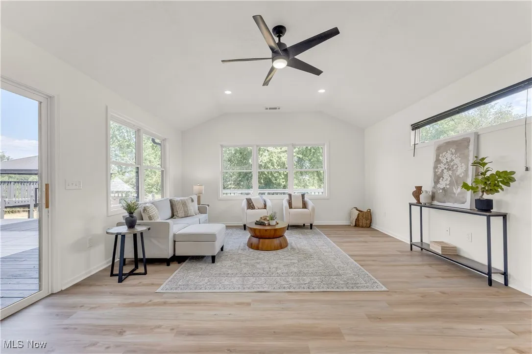 Living area with light wood-style floors, recessed lighting, vaulted ceiling, and a ceiling fan