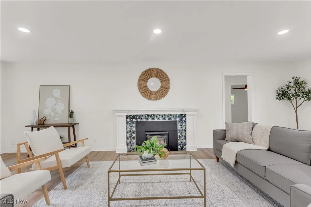 Living area with recessed lighting, wood finished floors, and a tile fireplace