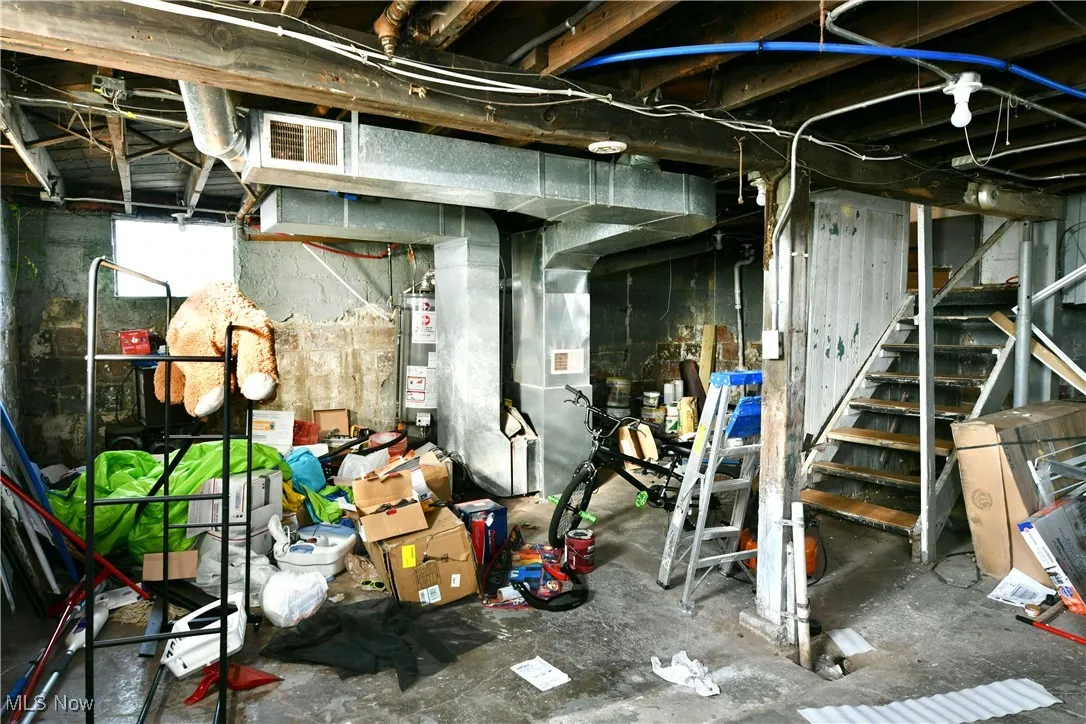 Basement with stairway, heating unit, and gas water heater