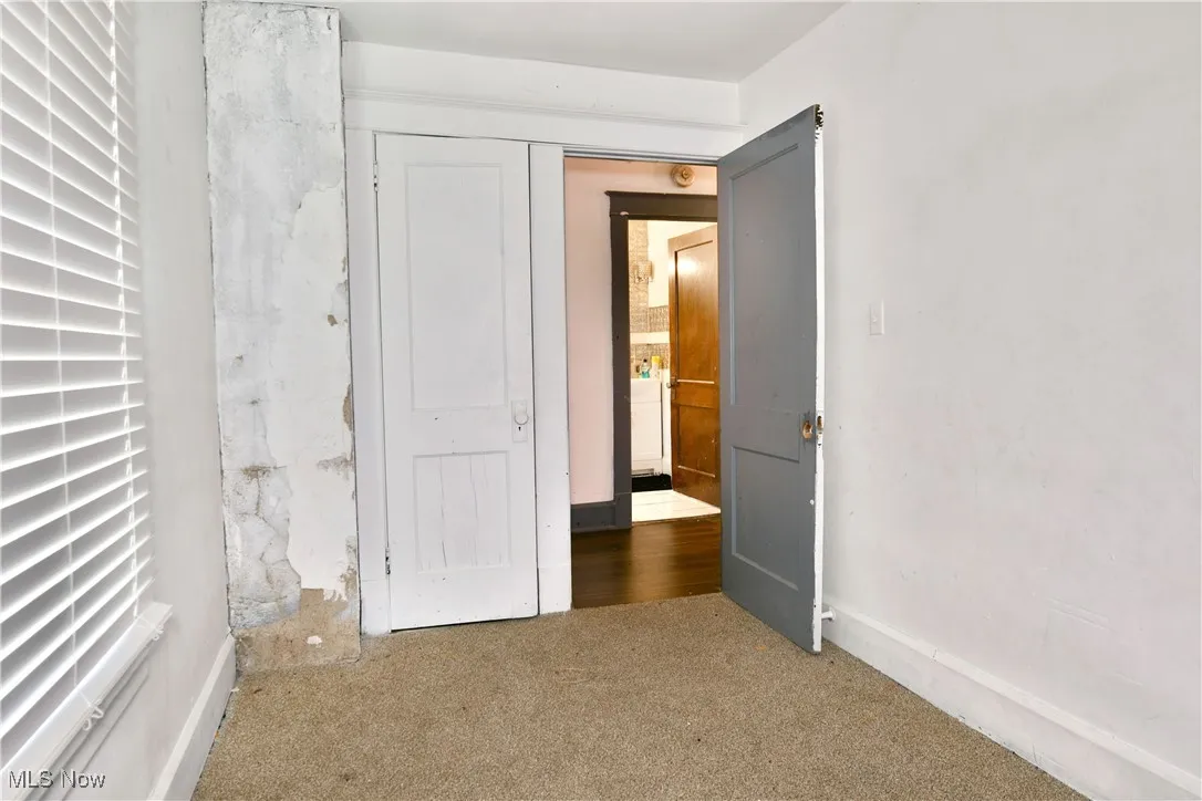 Unfurnished bedroom with carpet flooring and baseboards