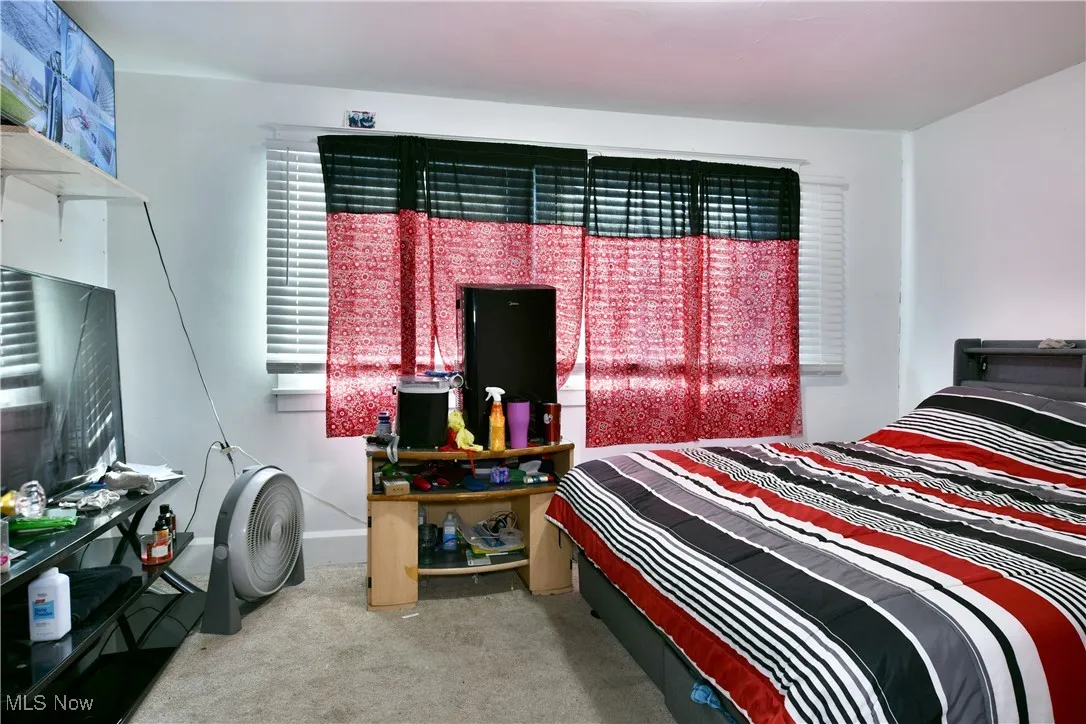 Bedroom featuring light colored carpet and baseboards
