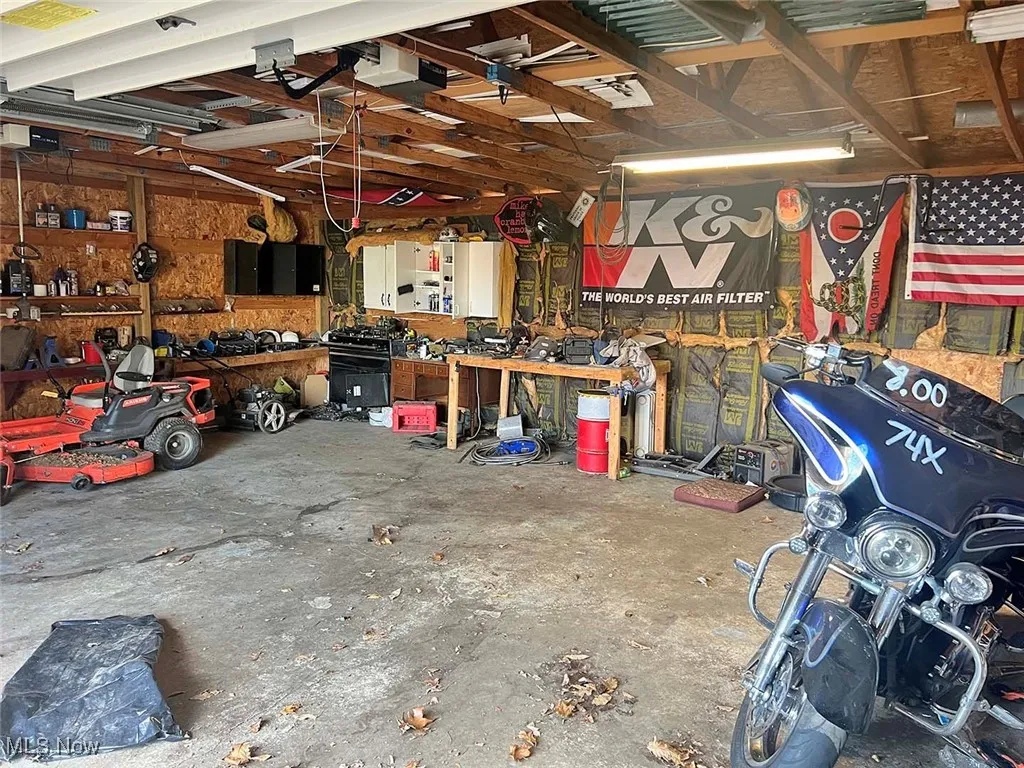 Garage featuring a workshop area and a garage door opener