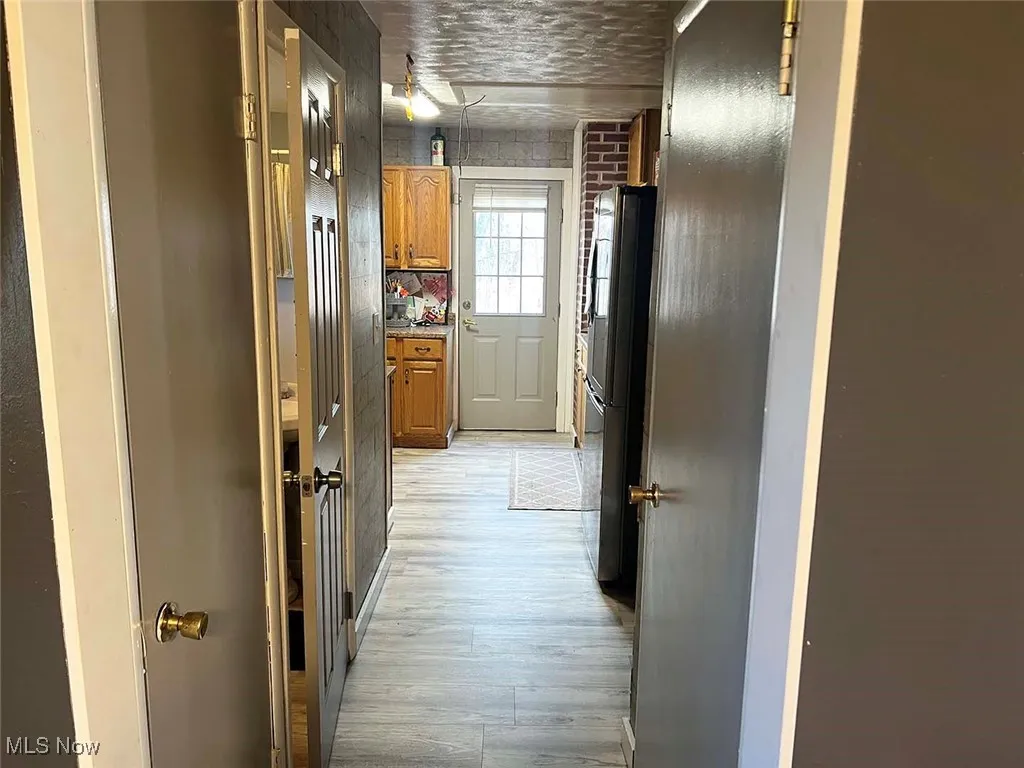 Corridor featuring light wood-type flooring