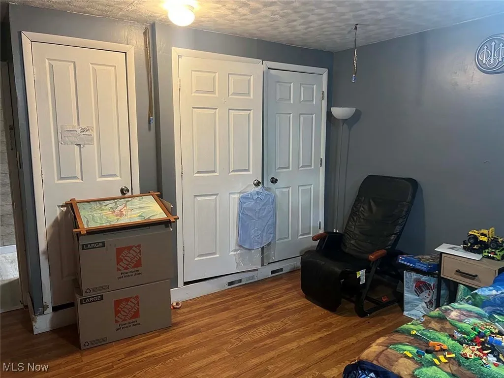 Bedroom featuring wood finished floors and a textured ceiling