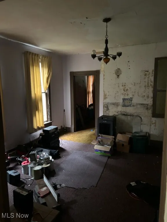 Living area featuring a chandelier and carpet flooring