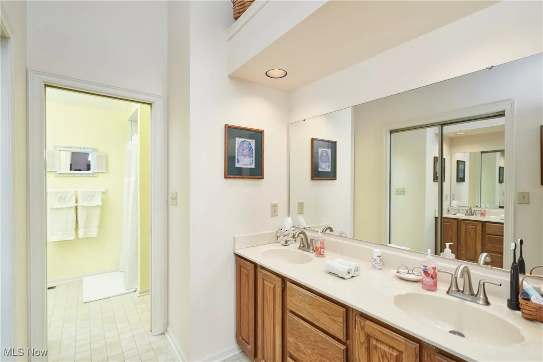 Bathroom with double vanity and light tile patterned floors