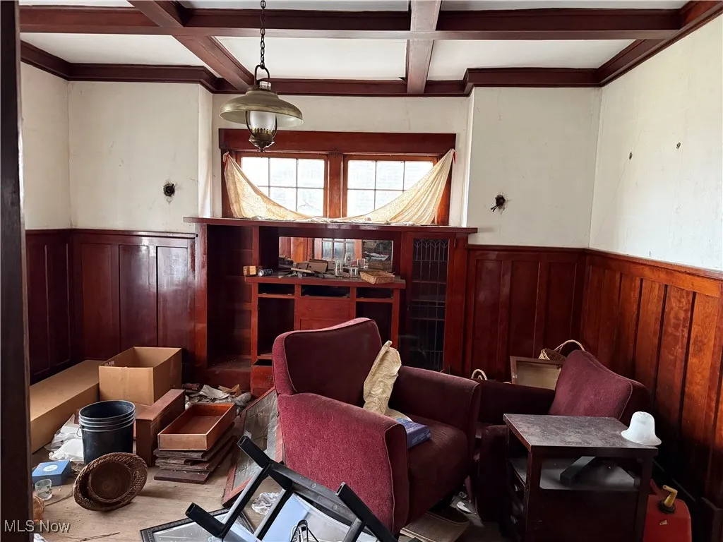 Living area with beamed ceiling, coffered ceiling, and wainscoting