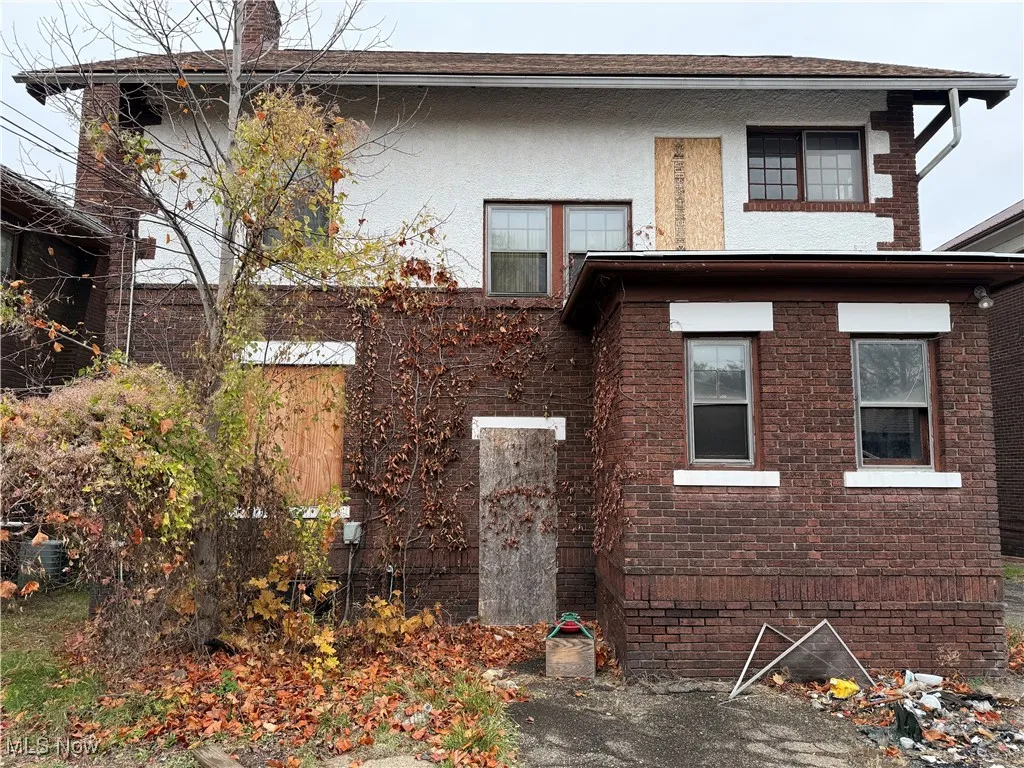 Back of house with stucco siding and brick siding