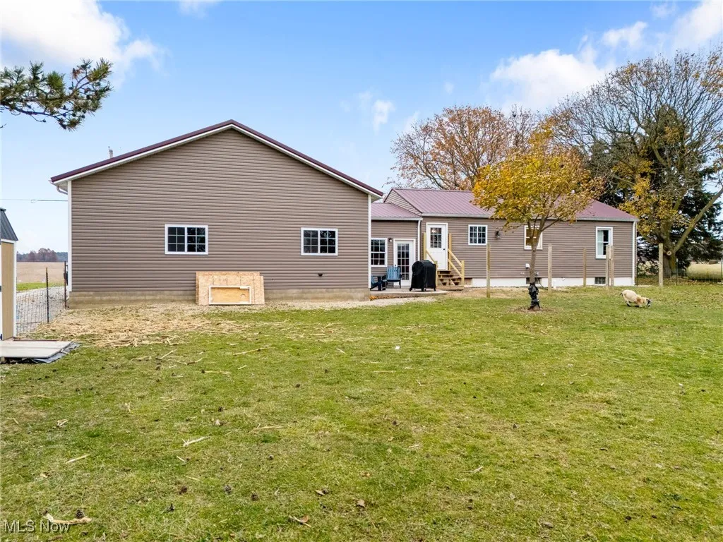 Rear view of house featuring a patio and a lawn