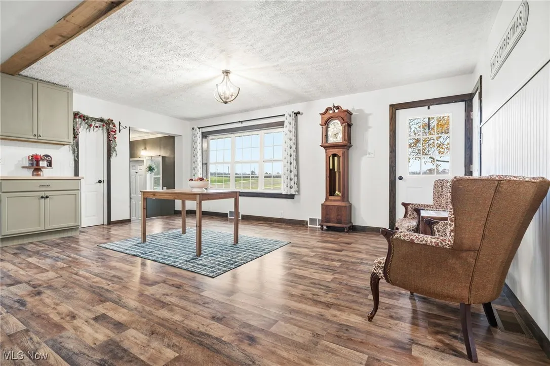 Office featuring a textured ceiling, dark wood-style flooring, and a chandelier