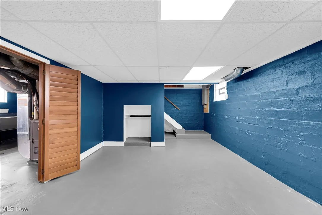 Below grade area with a paneled ceiling and heating unit