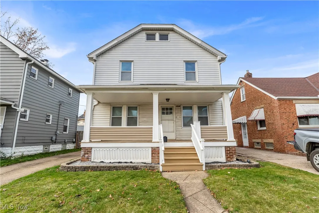 American foursquare style home featuring a front yard and covered porch