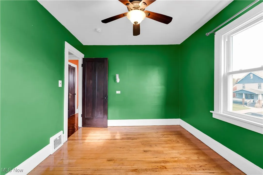 Spare room with wood finished floors and ceiling fan