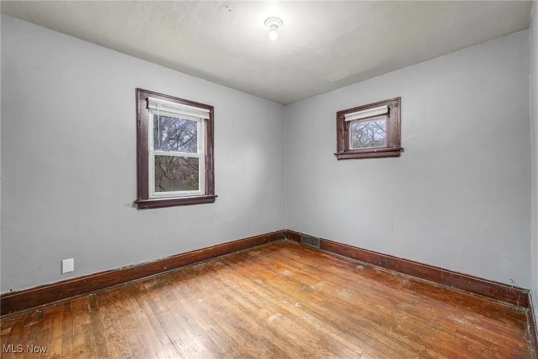 Spare room featuring hardwood / wood-style flooring and baseboards