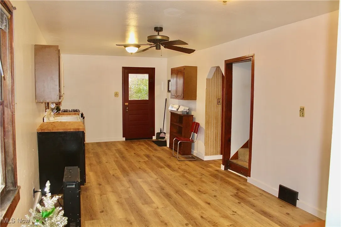 Entrance foyer with light wood-type flooring and a ceiling fan
