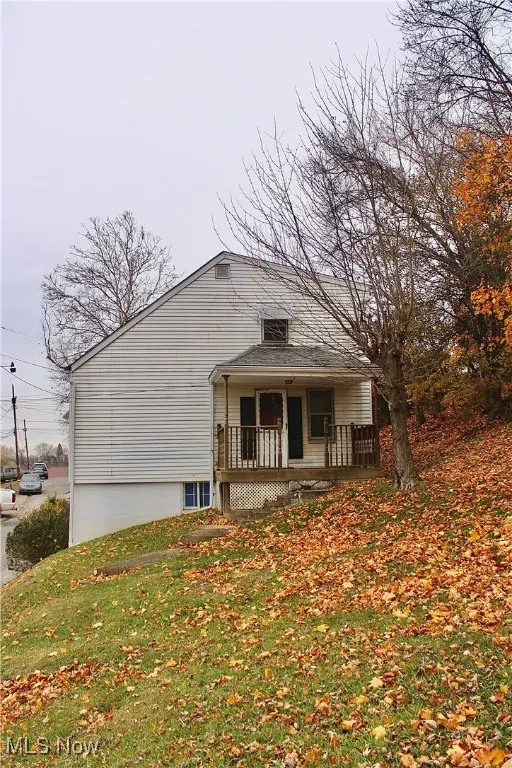 View of front of house with a front yard and a porch