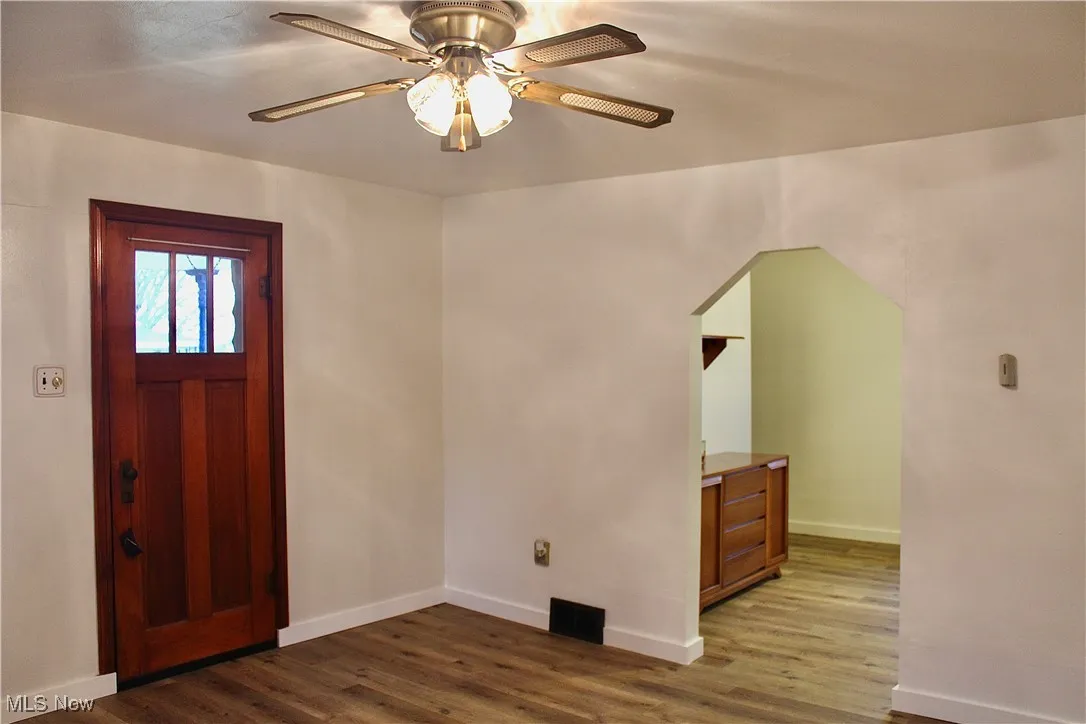 Foyer entrance with dark wood-style flooring and ceiling fan
