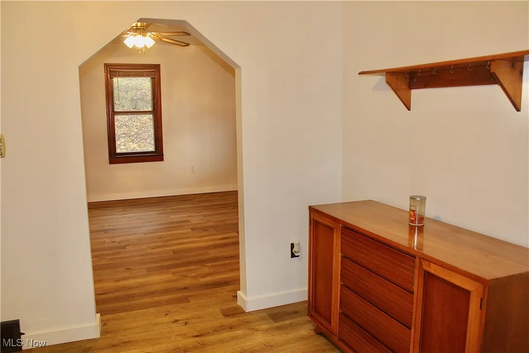 Hallway featuring light wood-type flooring and arched walkways