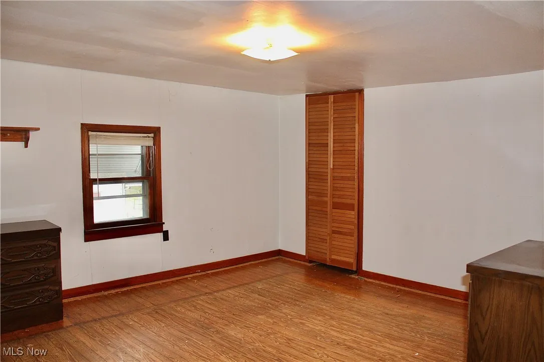 Unfurnished bedroom featuring light wood-style floors and a closet