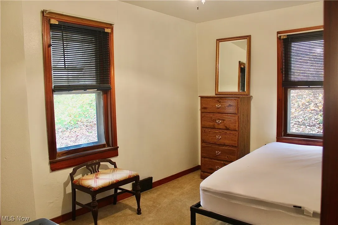 Bedroom with light carpet and baseboards