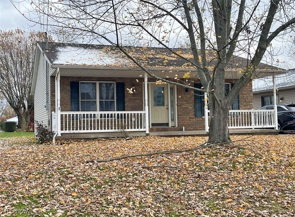 View of front facade with brick siding and a porch