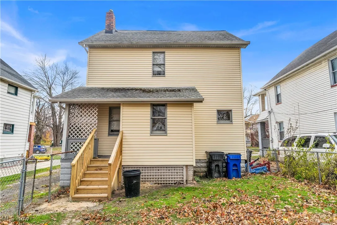 Rear view of property with a chimney, a gate, and a shingled roof