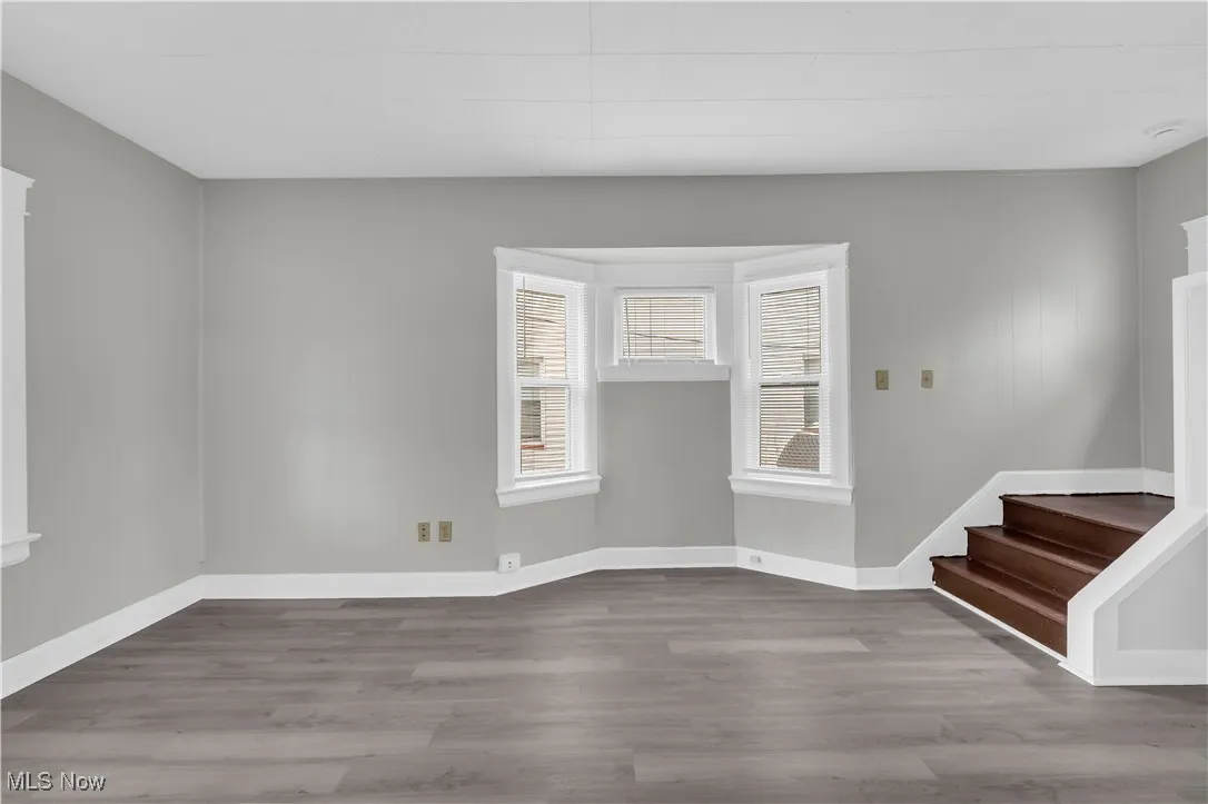 Spare room featuring wood finished floors and stairway