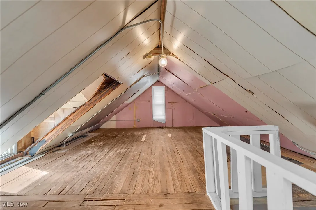 Bonus room with light wood-style floors and lofted ceiling