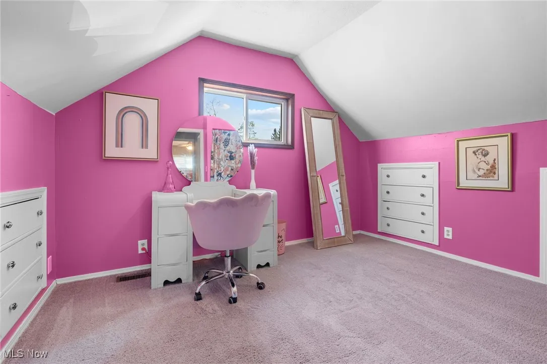 Office space featuring light carpet and vaulted ceiling