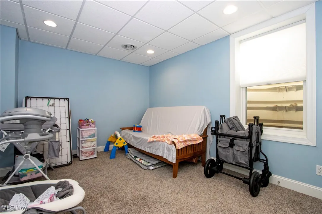 Carpeted bedroom with a paneled ceiling and recessed lighting