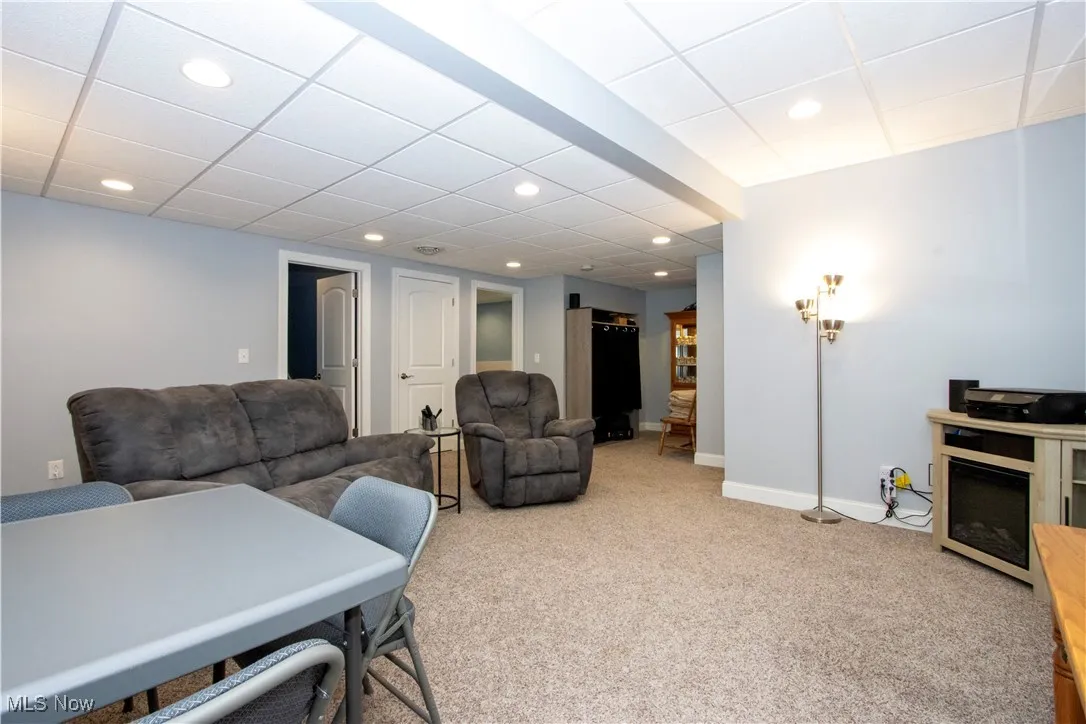 Living area featuring light carpet, a drop ceiling, and recessed lighting