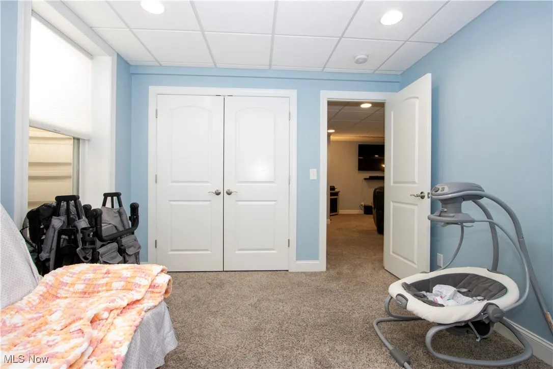 Bedroom featuring a paneled ceiling, light colored carpet, a closet, and recessed lighting