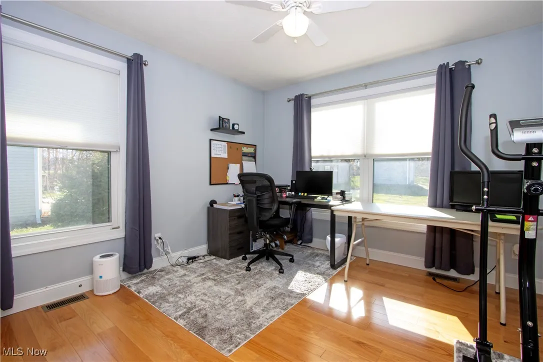 Office area featuring light wood-style flooring and ceiling fan
