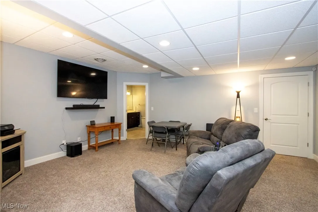 Living room with a drop ceiling, light carpet, and recessed lighting