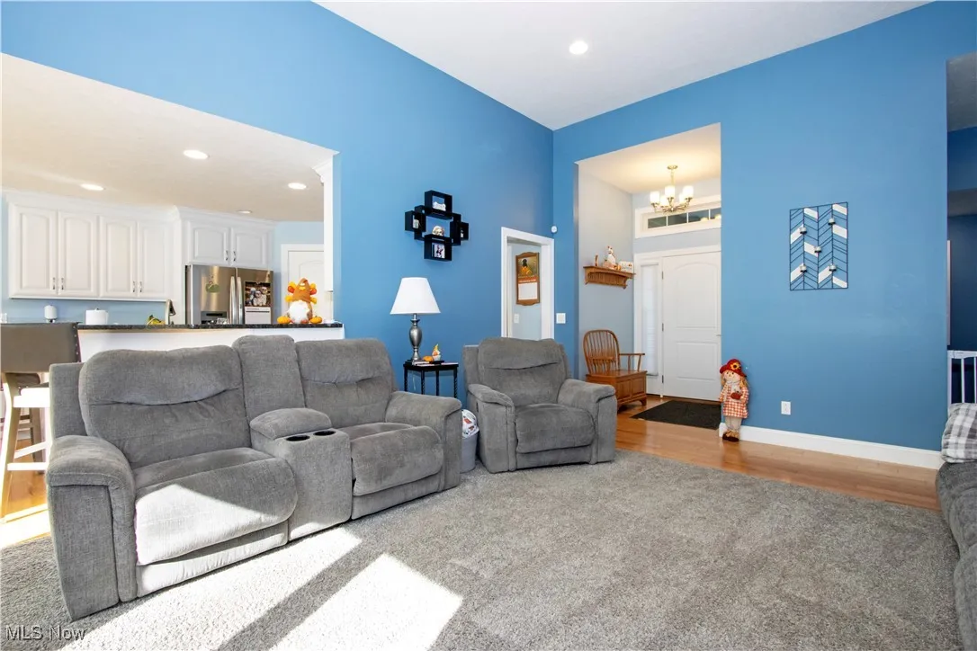 Living room featuring light carpet, recessed lighting, a chandelier, and light wood-type flooring