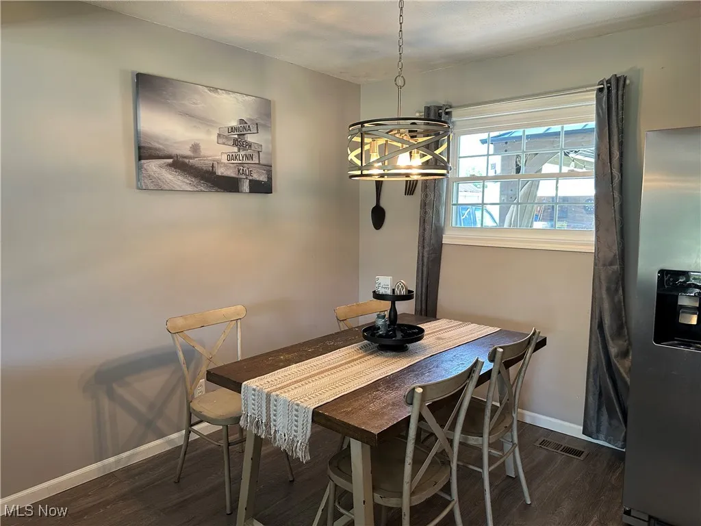 Dining area with dark wood-type flooring and baseboards