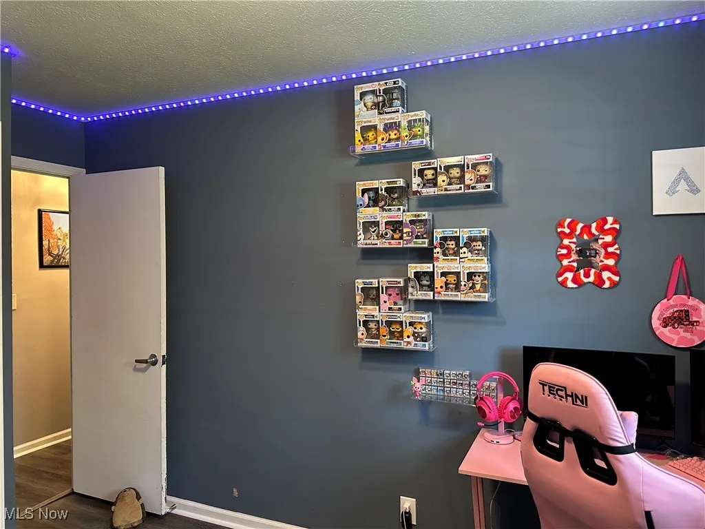 Playroom featuring a textured ceiling, an office area, and dark wood finished floors