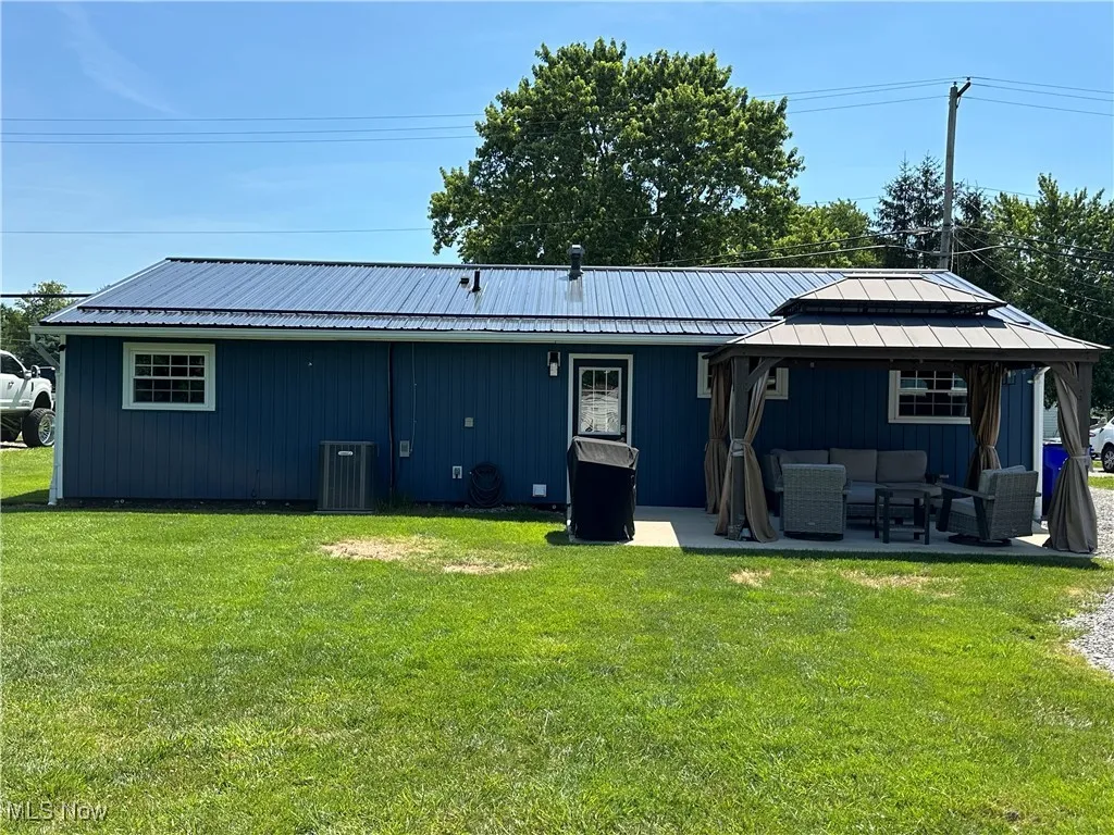 Rear view of property featuring an outdoor living space, a gazebo, a patio area, and a yard