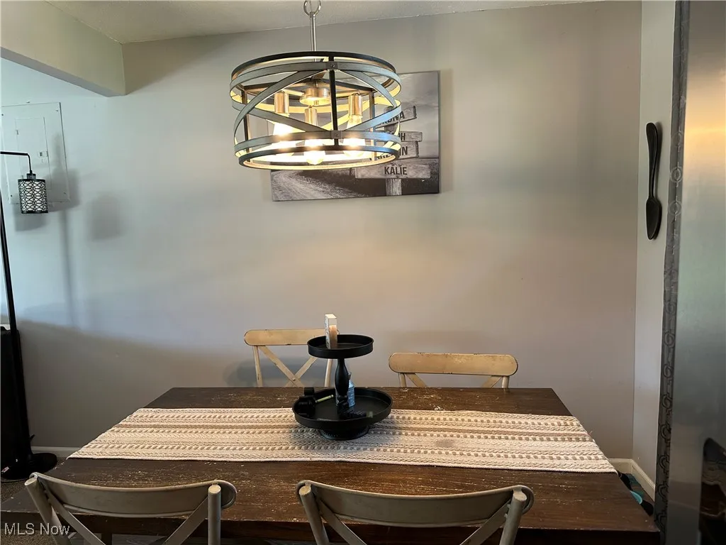 Dining space with electric panel and a chandelier