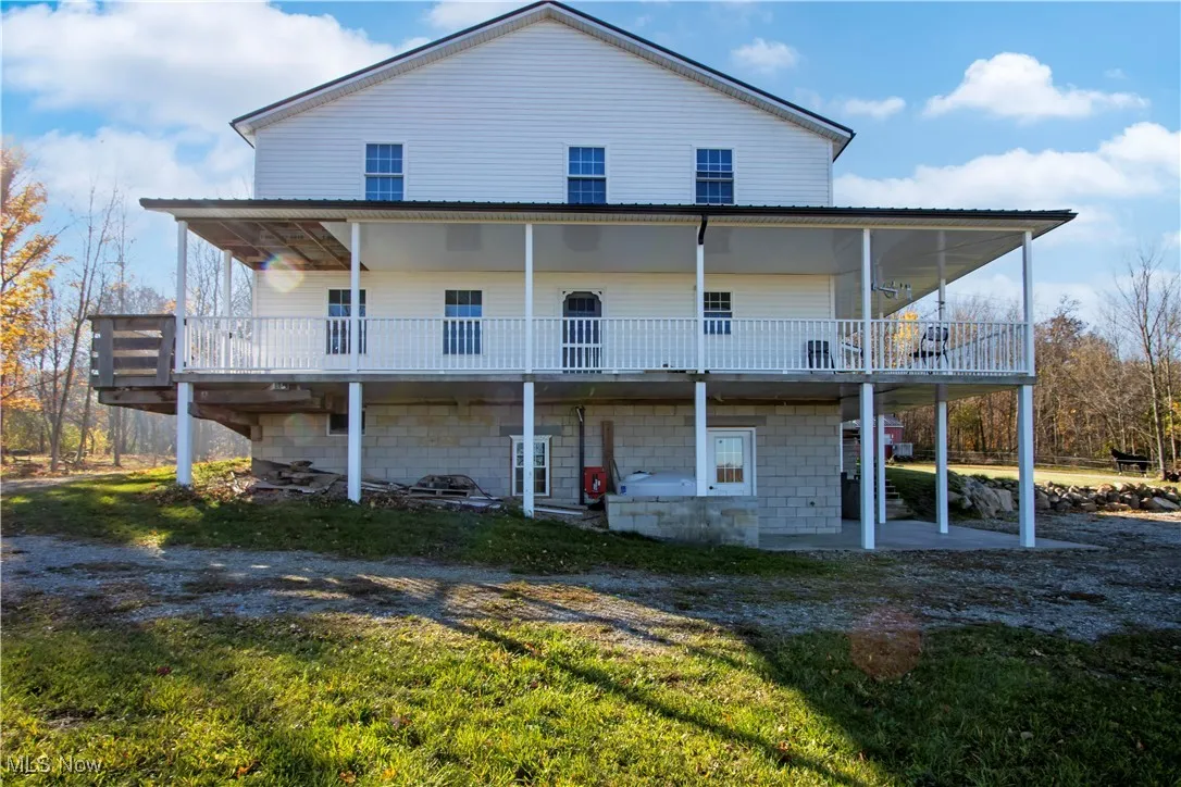 Rear view of house featuring a lawn and a porch