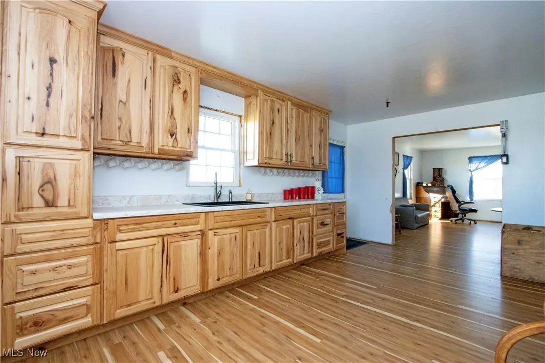 Kitchen featuring light wood finished floors, light countertops, light brown cabinetry, and plenty of natural light