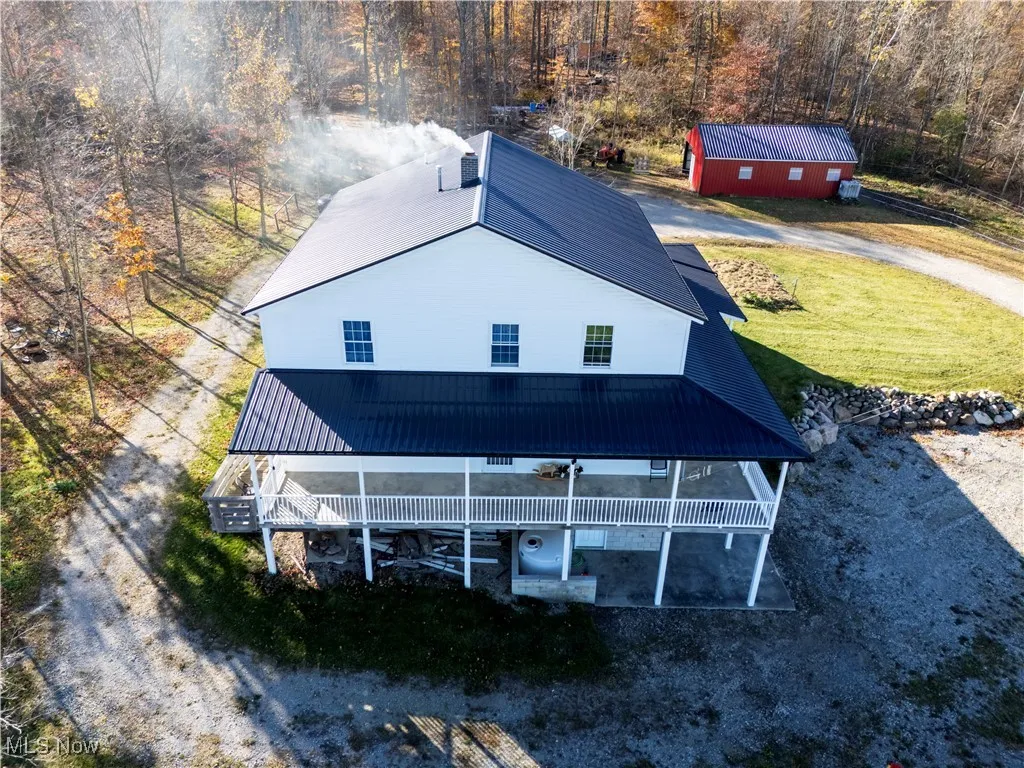 Rear view of house with a metal roof and a yard