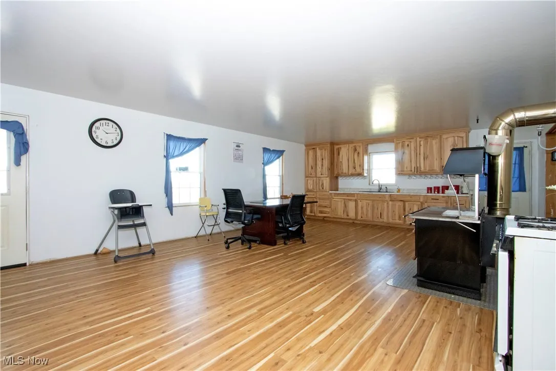 Kitchen featuring gas range oven, light wood-style floors, light brown cabinets, and light countertops
