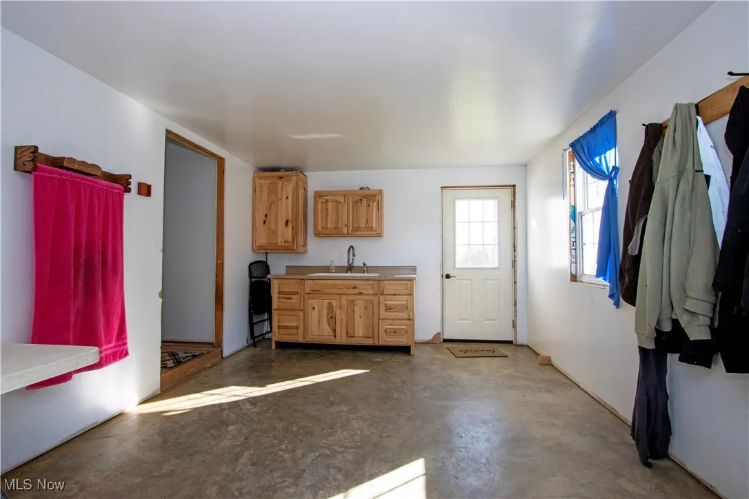 Kitchen featuring concrete flooring, light countertops, and light brown cabinets